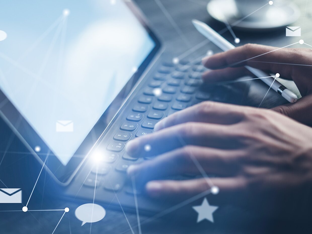 Elektronische Kommunikation Eine Person tippt auf einer Tastatur eines Tablets. Im Hintergrund sind schematische Symbole von Nachrichten und Verbindungen zu sehen, die digitale Kommunikation darstellen. Es gibt eine Tasse auf dem Tisch, was auf eine entspannte Arbeitsumgebung hindeutet.