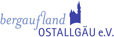 Logo des Vereins "bergaufland OSTALLGÄU e.V.". Der Schriftzug ist in blauen Buchstaben gehalten, begleitet von einer stilisierten Burg oder einem Turm.