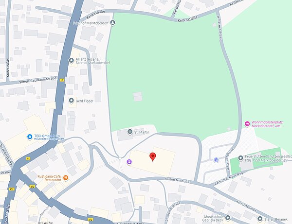 Stadtplan von Marktredwitz mit Straßen, Gebäuden und einem großen grünen Bereich. Ein Punkt ist markiert, der wahrscheinlich einen bestimmten Standort kennzeichnet, während Geschäfte und Restaurants in der Nähe abgebildet sind.