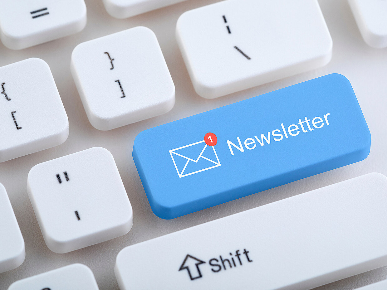 Eine Computer-Tastatur mit einer blauen Taste, die das Wort „Newsletter“ und ein Symbol für eine neue Nachricht zeigt. Die anderen Tasten sind in Weiß gehalten.