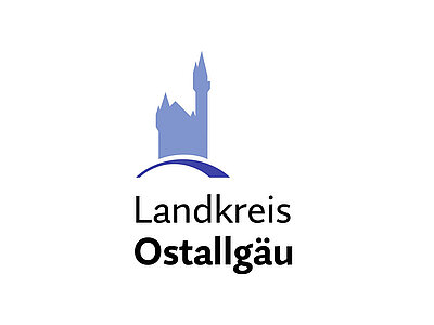 Logo des Landkreises Ostallgäu mit einer stilisierten Burg im Hintergrund und dem Schriftzug "Landkreis Ostallgäu". Die Farbgestaltung ist in Blau- und Grautönen gehalten.