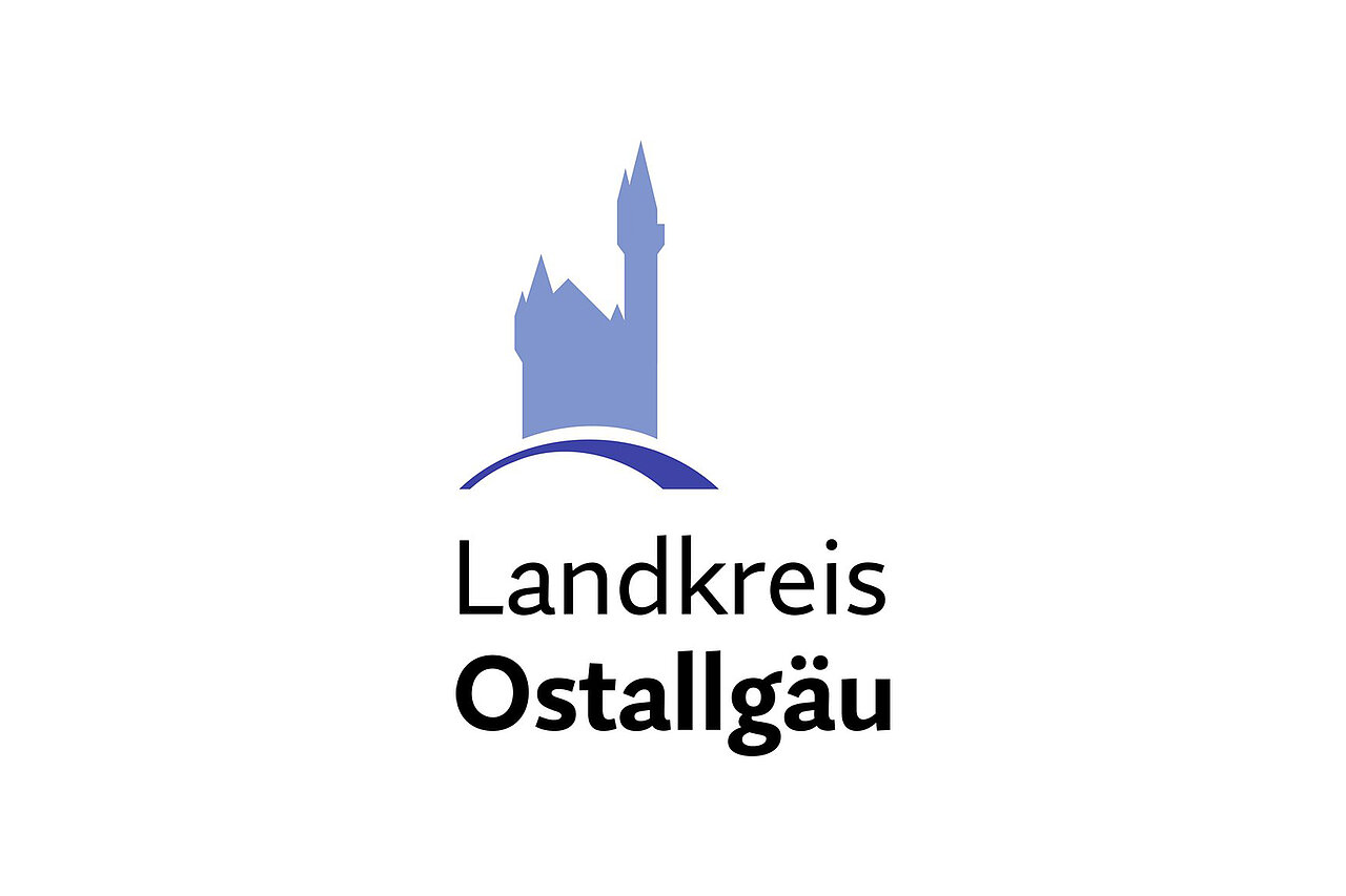 Logo des Landkreises Ostallgäu mit einer stilisierten Burg im Hintergrund und dem Schriftzug "Landkreis Ostallgäu". Die Farbgestaltung ist in Blau- und Grautönen gehalten.