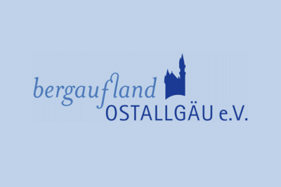 Logo des Vereins "bergaufland OSTALLGÄU e.V." in Blautönen. Der Schriftzug zeigt den Namen des Vereins und ein stilisiertes Schloss. Der Hintergrund ist hellblau.