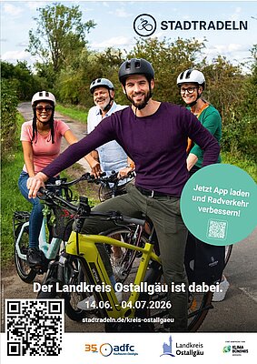 Eine Gruppe von vier Radfahrern steht auf einem Radweg, lächelnd und in freizeitlicher Kleidung. Im Hintergrund sind Bäume zu sehen. Der Text informiert über eine Radaktionswoche im Landkreis Ostallgäu von 14.06. bis 04.07.2026.