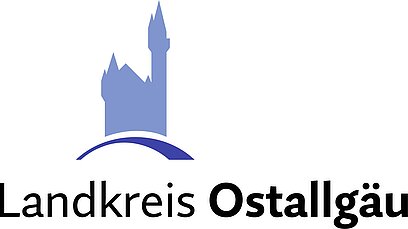Logo des Landkreises Ostallgäu, bestehend aus einer stilisierten blauen Burgarbeiten im Hintergrund und dem Schriftzug "Landkreis Ostallgäu" in schwarzer Schrift.