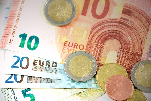 Ein Haufen Euro-Banknoten und -Münzen. Zu sehen sind Scheine in den Nennwerten 5, 10 und 20 Euro sowie verschiedene Euro-Münzen.